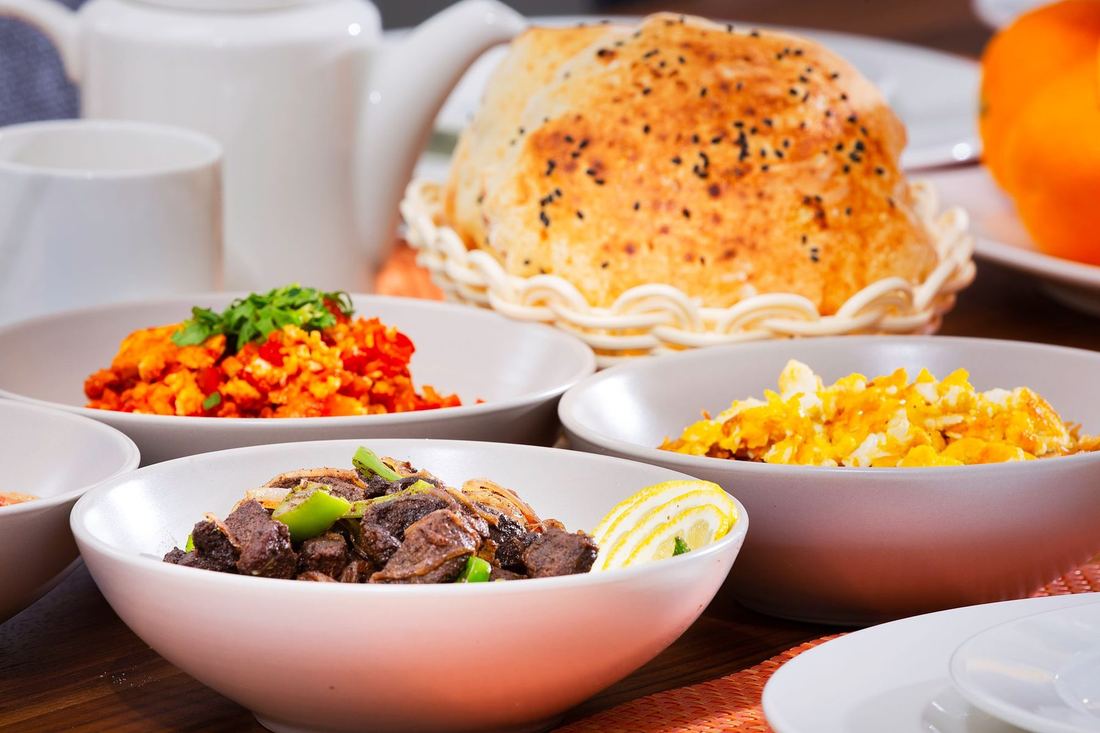 A long breakfast spread with pastries, eggs and small dishes