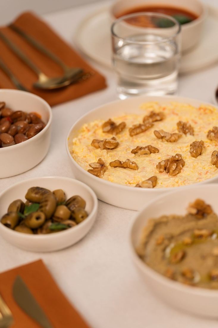 Small bowls of dips and olives on a laid table
