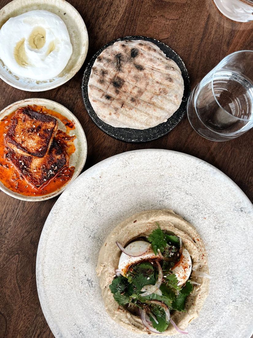Mezze dishes laid out on a wooden board, seen from above